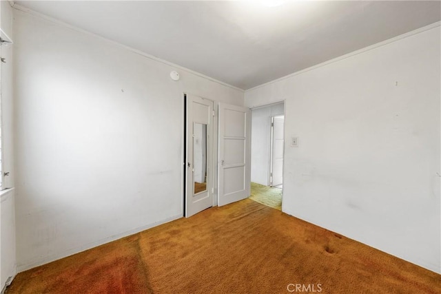 empty room with crown molding and carpet flooring