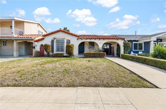 mediterranean / spanish home with a front lawn and a carport