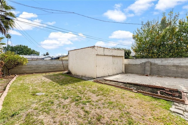 view of yard featuring a shed and a patio