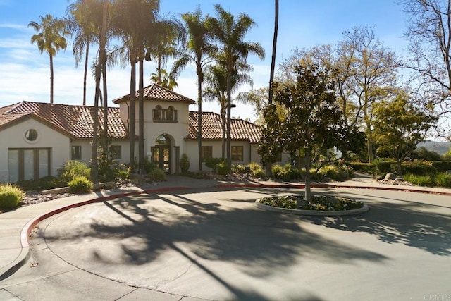 mediterranean / spanish house with stucco siding and a tiled roof
