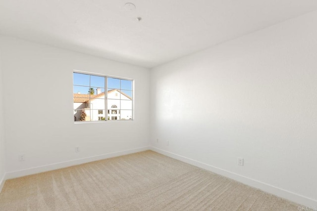 carpeted spare room featuring baseboards