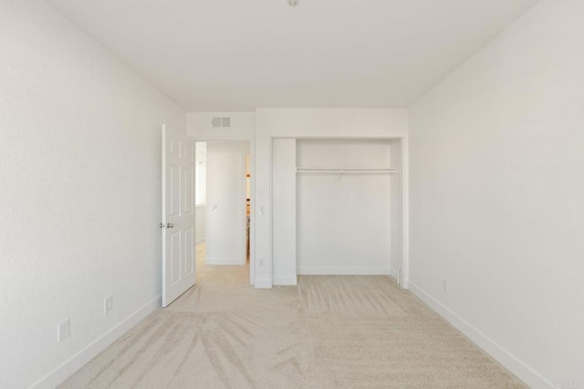 unfurnished bedroom with baseboards, visible vents, a closet, and carpet flooring