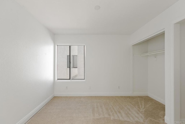 unfurnished bedroom featuring baseboards, carpet flooring, and a closet
