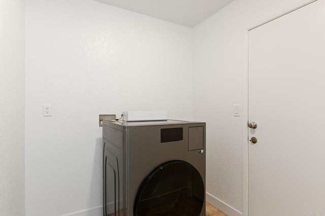 laundry area with laundry area, baseboards, and washer / dryer