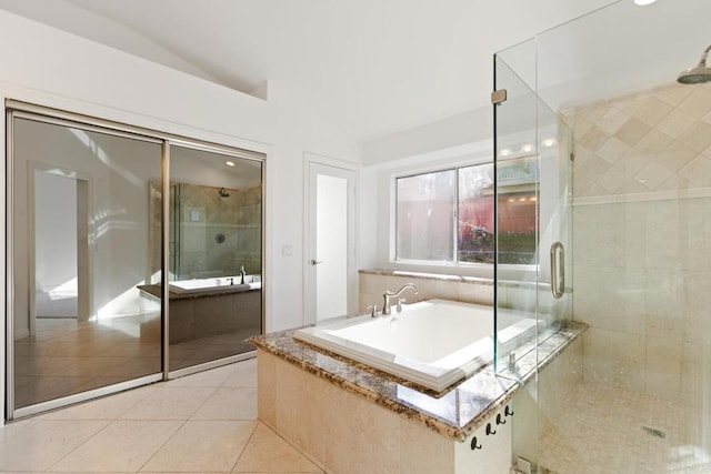 full bathroom with lofted ceiling, a garden tub, tile patterned flooring, and a stall shower