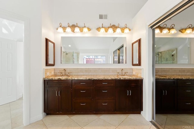 bathroom with tile patterned flooring, visible vents, an enclosed shower, and a sink
