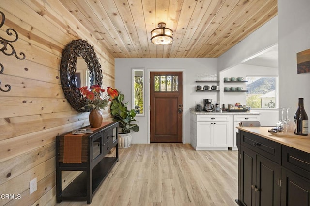 foyer featuring wood ceiling, a healthy amount of sunlight, and light wood-type flooring