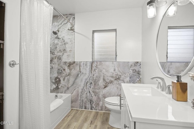 full bathroom featuring tile walls, hardwood / wood-style flooring, vanity, shower / tub combo, and toilet