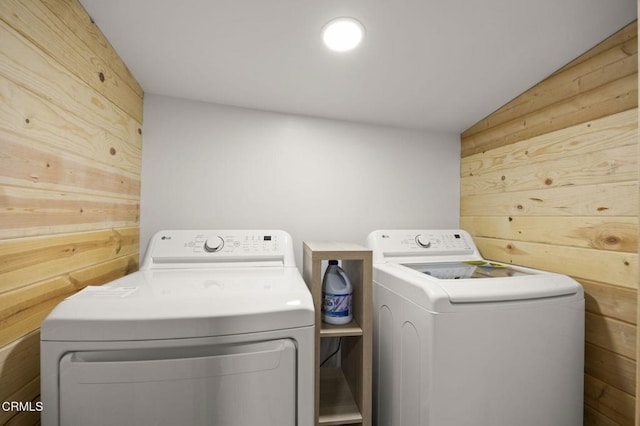 laundry room featuring washer and clothes dryer and wood walls