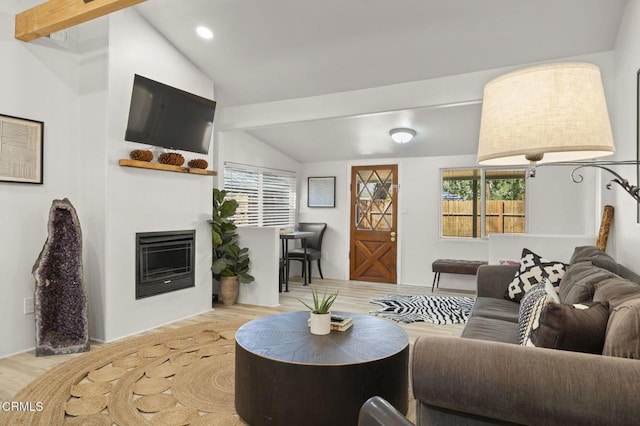 living room featuring vaulted ceiling with beams and light hardwood / wood-style flooring