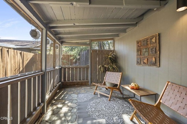 unfurnished sunroom featuring beamed ceiling and wood ceiling