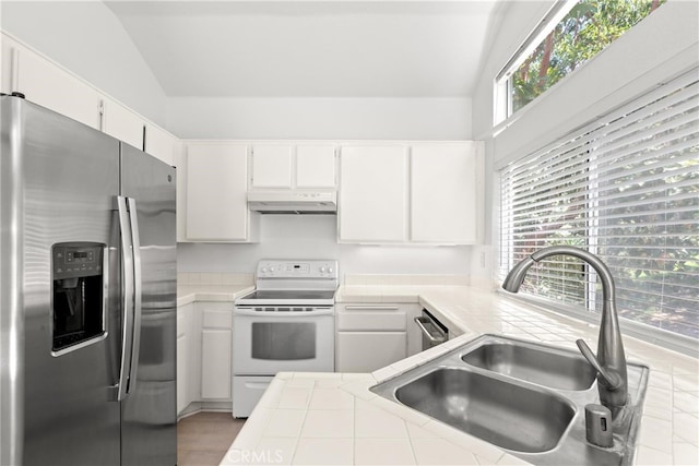 6 Daytona Dr Unit 128, Laguna Niguel, CA 92677 - kitchen featuring appliances with stainless steel finishes, under cabinet range hood, tile countertops, plenty of natural light, and vaulted ceiling