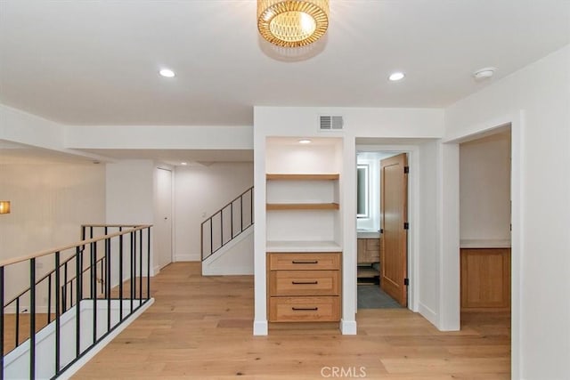 interior space featuring recessed lighting, visible vents, light wood-style flooring, and stairs