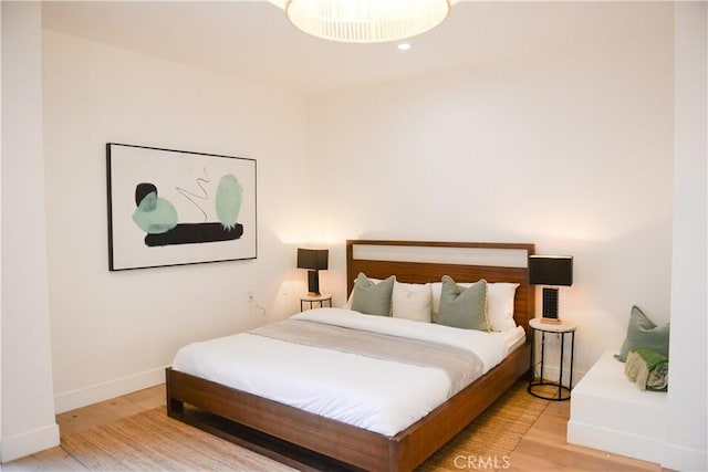 bedroom with baseboards and wood finished floors