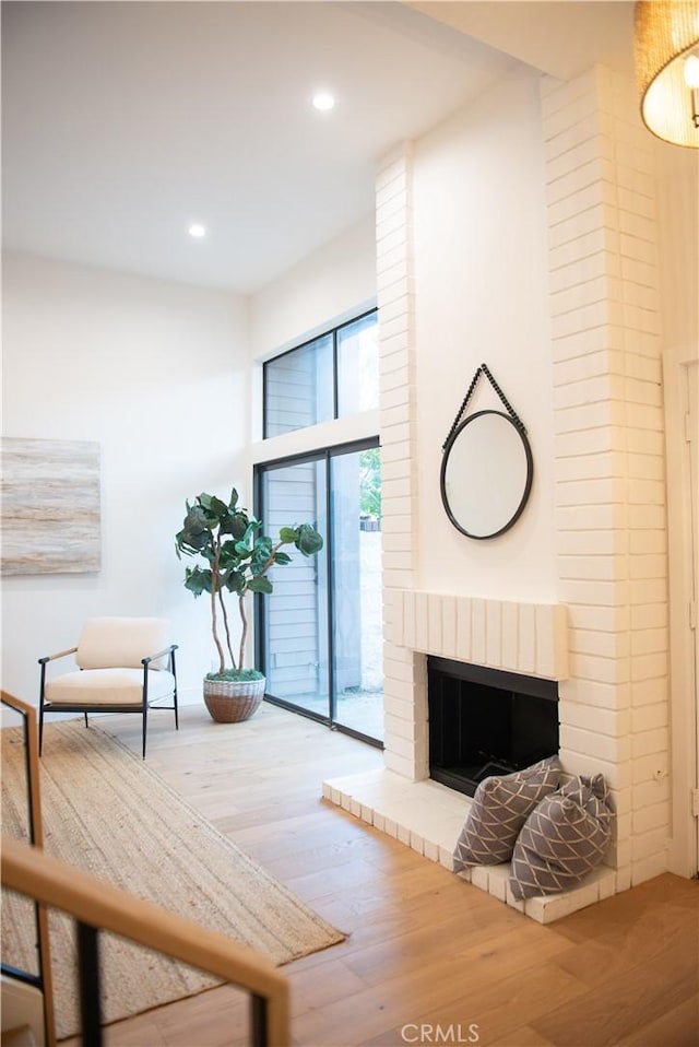 living room featuring recessed lighting, wood finished floors, and a fireplace