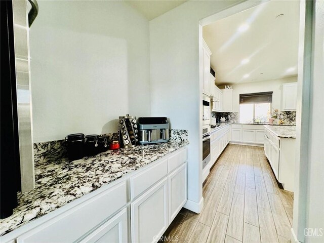 826 Jacob Creek Dr, Bakersfield, CA 93314 - kitchen featuring white cabinetry, light stone countertops, stainless steel oven, and decorative backsplash