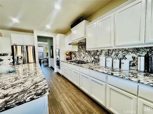 826 Jacob Creek Dr, Bakersfield, CA 93314 - kitchen with dark wood-type flooring, appliances with stainless steel finishes, white cabinetry, light stone counters, and decorative backsplash