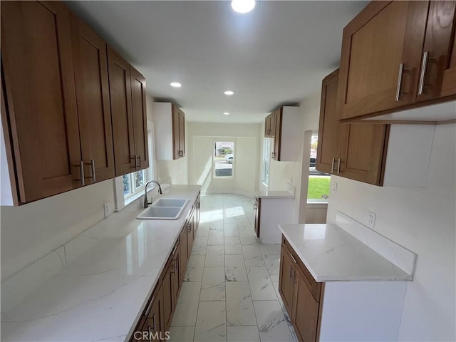 kitchen featuring sink and light stone counters