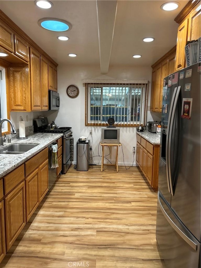 kitchen with a sink, fridge with ice dispenser, stainless steel gas stove, and brown cabinetry