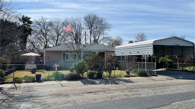 view of front facade with a carport, driveway, a fenced front yard, and a chimney