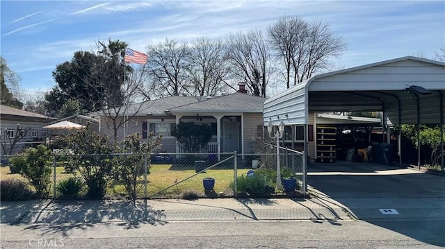 view of front facade with a detached carport, concrete driveway, and a fenced front yard