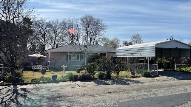 view of front of home with a detached carport, concrete driveway, and a fenced front yard