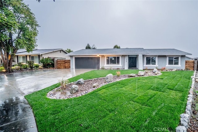 single story home featuring a garage and a front lawn