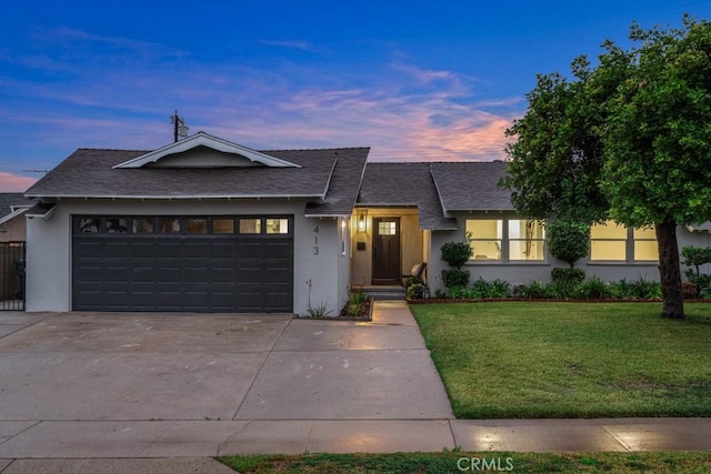 view of front facade featuring a garage, concrete driveway, a front lawn, and stucco siding