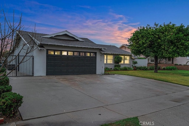 view of front of home featuring concrete driveway, stucco siding, roof with shingles, an attached garage, and a front yard