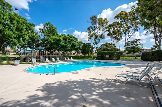 pool with a patio and fence
