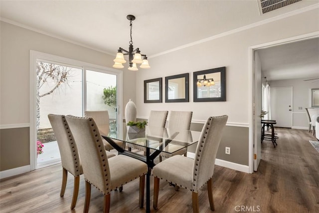 dining space with crown molding, a notable chandelier, and visible vents