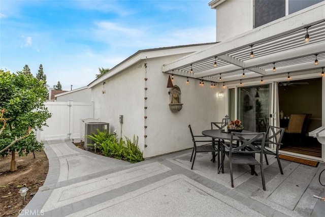 view of patio with fence, central AC, a pergola, and outdoor dining space