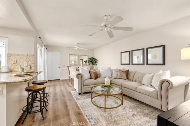 living room featuring a ceiling fan and light wood-style flooring