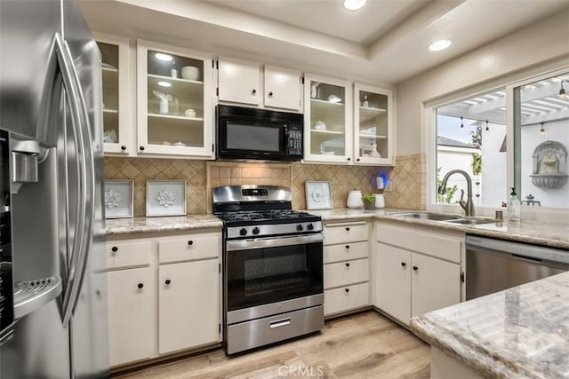 16 Wayfarer, Irvine, CA 92614 - kitchen with stainless steel appliances, a sink, light wood-style floors, white cabinets, and recessed lighting