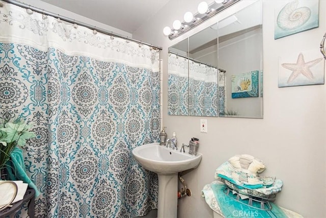 bathroom featuring sink, toilet, and a shower with shower curtain