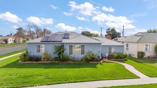 view of front facade with a front lawn and solar panels