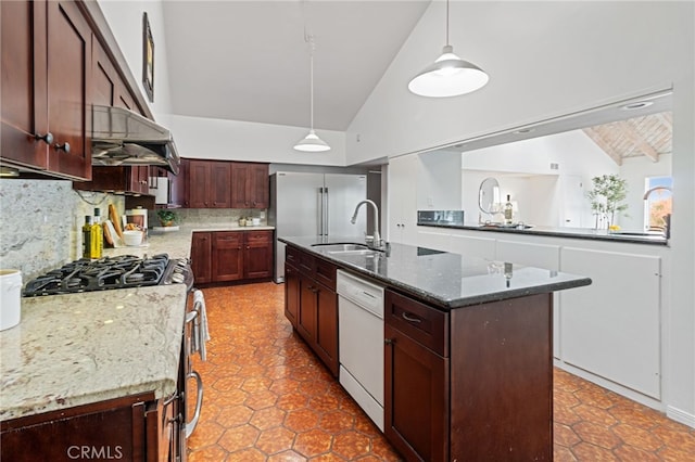 kitchen with sink, hanging light fixtures, dark stone countertops, appliances with stainless steel finishes, and a kitchen island with sink