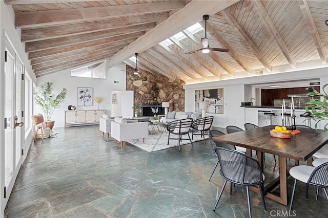 interior space featuring beam ceiling, wooden ceiling, ceiling fan, and a skylight