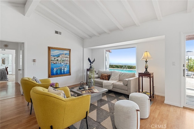 living room featuring high vaulted ceiling, light hardwood / wood-style floors, beamed ceiling, and a water view