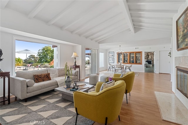 living room with an inviting chandelier, hardwood / wood-style flooring, high vaulted ceiling, and beamed ceiling