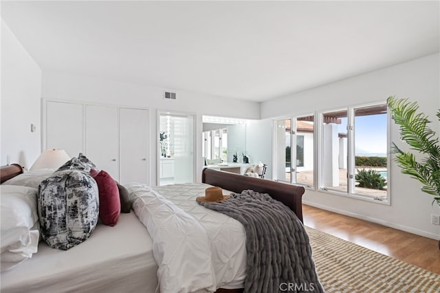 bedroom featuring connected bathroom and hardwood / wood-style floors