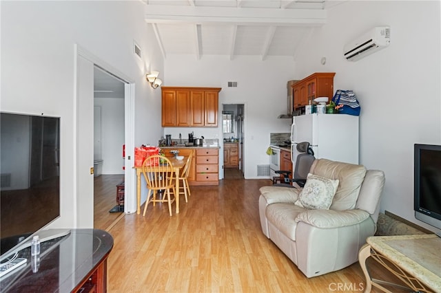 living room featuring beamed ceiling, high vaulted ceiling, a wall mounted air conditioner, and light hardwood / wood-style floors
