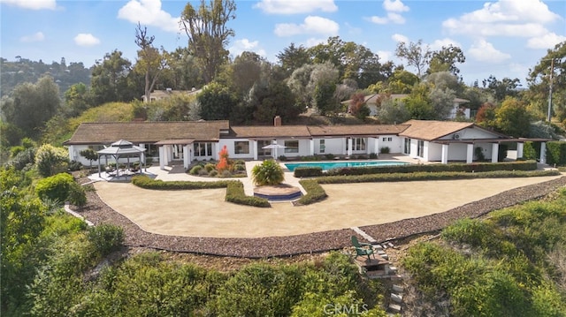 back of property featuring a gazebo and a patio area