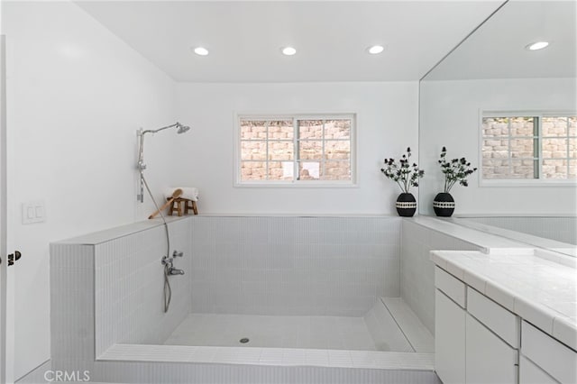 bathroom with vanity and a tile shower