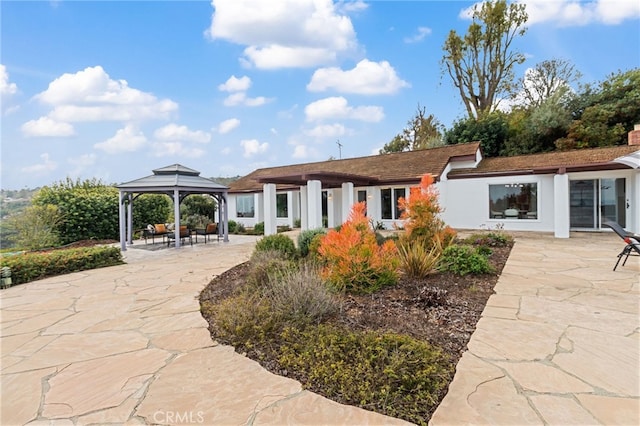 rear view of house featuring a gazebo and a patio area