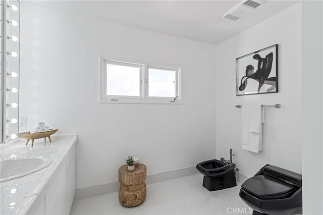 bathroom with a bidet, vanity, and toilet