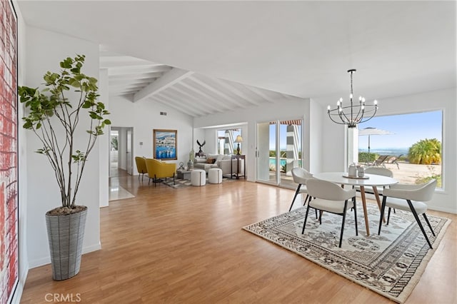 dining space featuring lofted ceiling with beams, light wood-type flooring, and an inviting chandelier
