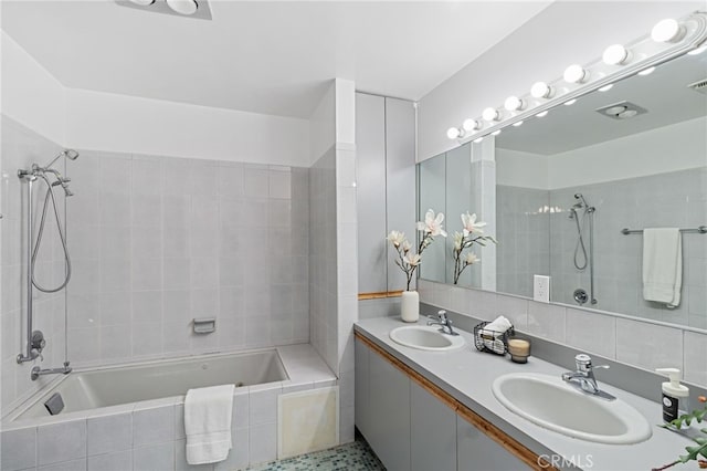 bathroom featuring tiled shower / bath and vanity