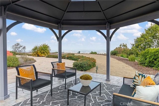 view of patio with an outdoor living space, a gazebo, and a water view