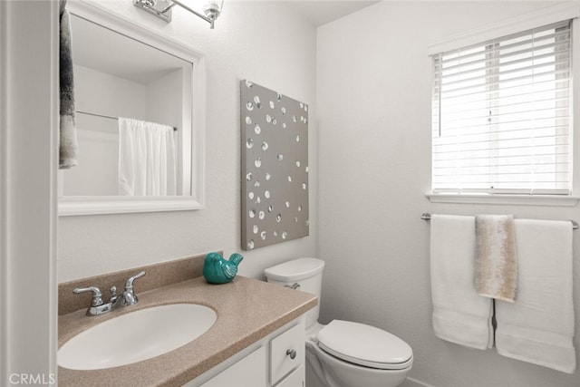 bathroom featuring a shower with curtain, vanity, and toilet